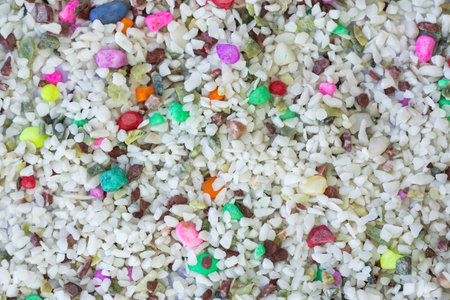Multicolor quartz aquarium substrate. Colorful decorative gravel background. Garden pond gravel...