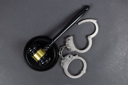 Law concept. Gavel and handcuffs on dark background.の写真素材