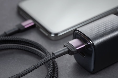 AC charger adapter and smartphone on a gray background.