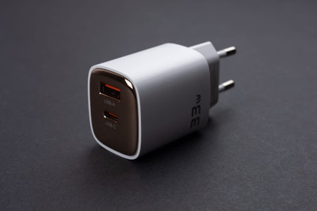 white smartphone charger on dark background. Charger and USB cable type C on dark background.