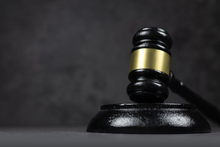 Black judges gavel on the table on a dark background.