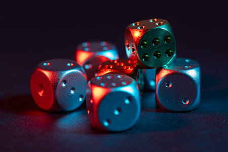 Colorful metallic dice on black background.