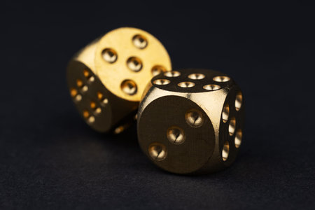 Two golden dice on black background.