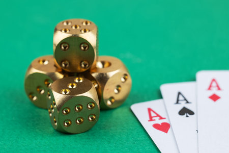 three aces cards and two dice on a green background.