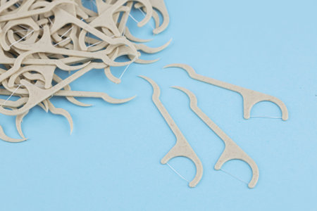 Eco friendly corn starch dental toothpick with dental floss on blue background.