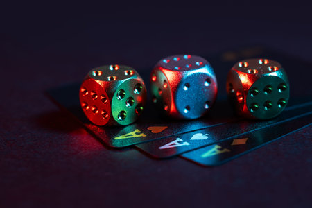 three aces cards and three dice on a dark background.