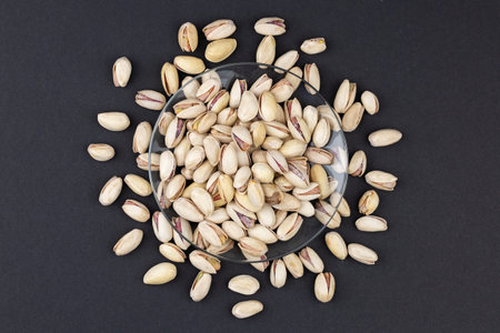 Salted Pistachios for Beer, Macro, on black Background of a Beer Snack of Salted Pistachio Nuts....