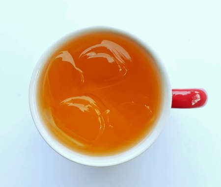 Closeup top view of a cup of orange cocktail on white background, selective focus.の素材