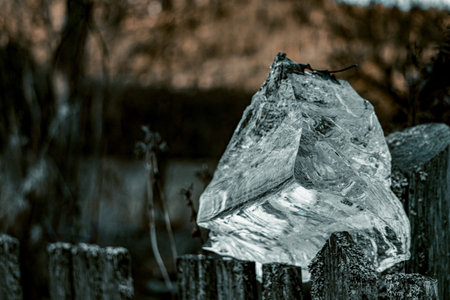 Ice on a wooden fence in the countryside. Shallow depth of field. Toned.