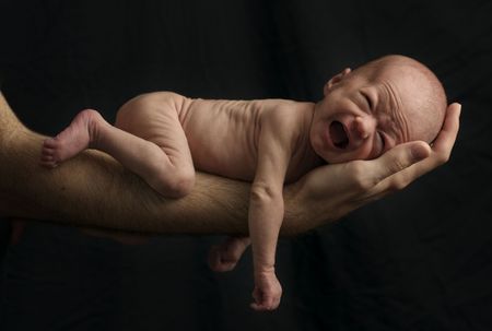 premature infant cries on father's armの写真素材
