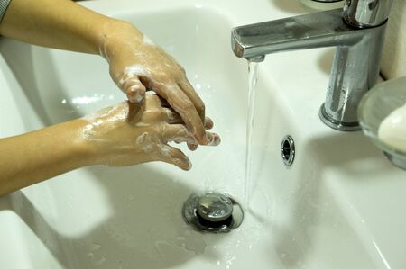 The boy thoroughly washes his hands with soap. Outside COVID 19の写真素材