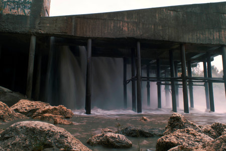 A small dam, on a small mountain river, on a city power station, in cloudy weatherの写真素材
