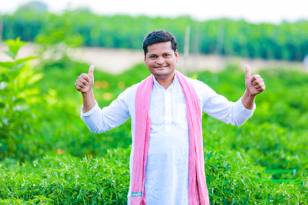 Indian Happy farmer holding green chilli , green chilli farming, young farmerの写真素材