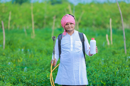 Young indian farmer showing Smart phone , Farmer talking on phone in farm, happy indian farmerの写真素材