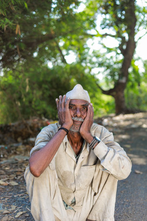 Maharashtra , India - April 2023 Indian old farmer, loss in farm , Old Indian men sitting tired, hungry old manのeditorial素材