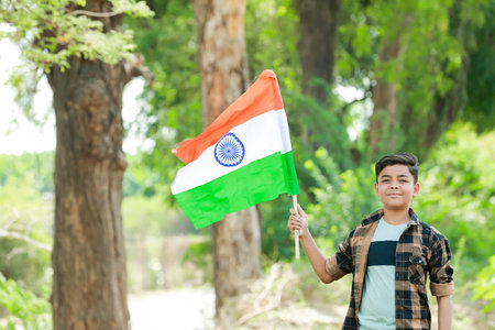 Indian boy holding national flag in farm, happy boy, national flag, poor kids