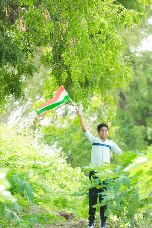Indian boy holding national flag in farm, happy boy, national flag, poor kids