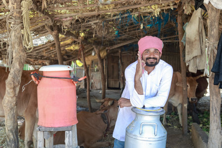 Happy Indian farmer selling milk in farm - concept of milk production agri busines, rural India, growth and agricultureの写真素材