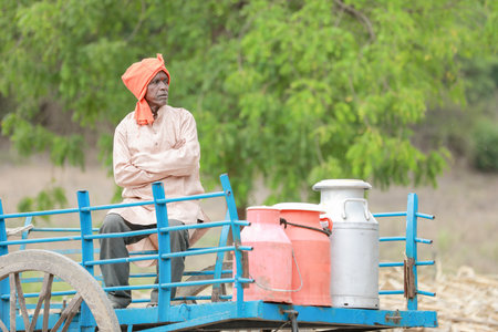 Happy Indian farmer selling milk in farm - concept of milk production agri busines, rural India, growth and agricultureの写真素材