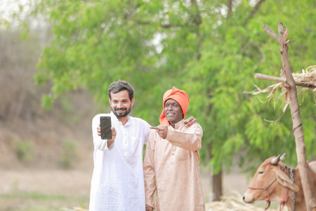 Group of two Indian male farmer, using mobile phone in farmの写真素材