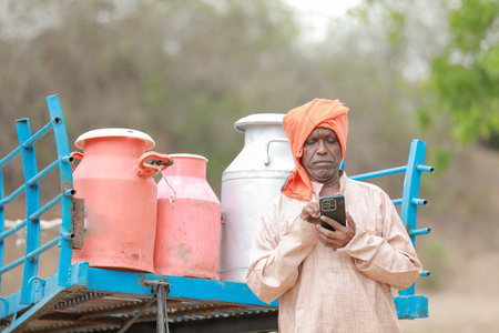 Happy Indian farmer selling milk in farm - concept of milk production agri busines, rural India, growth and agricultureの写真素材