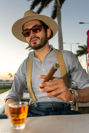 Vertical photo of a hipster at outdoor bar in a tropical destination