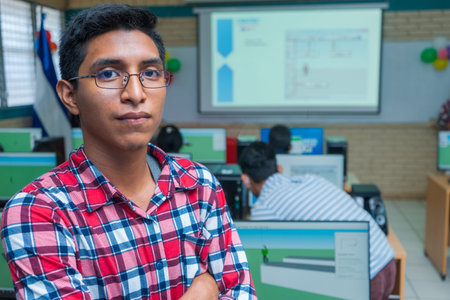 Portrait of a young Latin Central American man in glasses with his arms crossed and a slight smile...