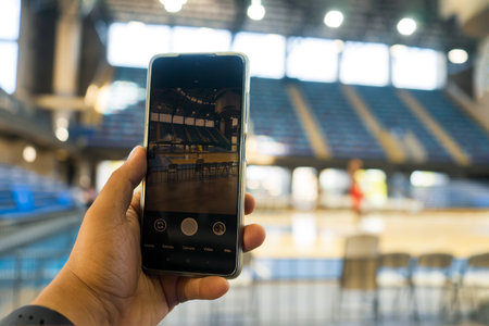 Filming with the cell phone the basketball practice of a professional team in a gym without spectatorsの写真素材
