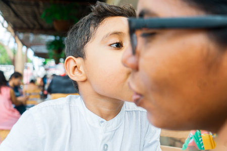Latin son kissing his mother on the cheek
