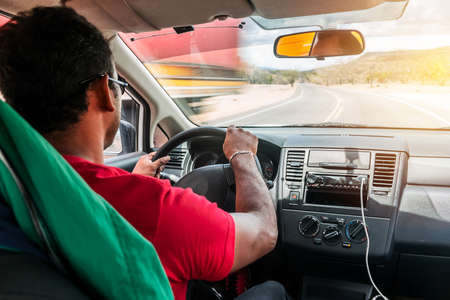 Horizontal photo of an unrecognizable black man driving his car on a highway in Nicaragua, Central Americaの写真素材