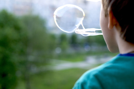 Boy blowing bubblesの写真素材