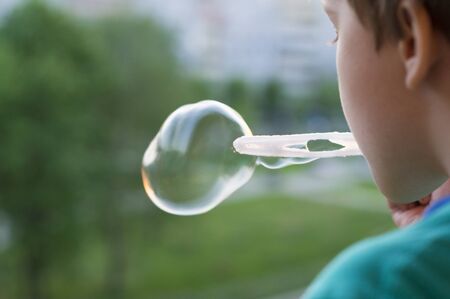 Boy blowing bubblesの写真素材