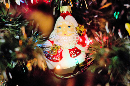 Christmas tree decoration with Santa Claus doll and lights in the background.