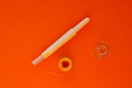Nail polish and manicure tools on orange background. Top view.