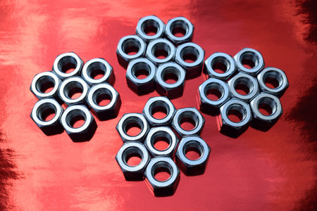 Set of nuts and bolts on red background. Selective focus.