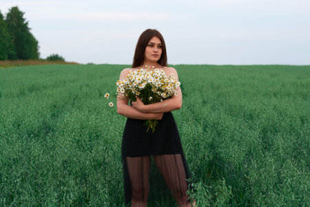 beautiful girl with a bouquet of daisies in a field of flowers.