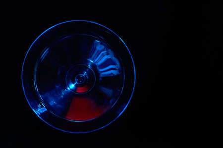 Martini glass with blue color on black background
