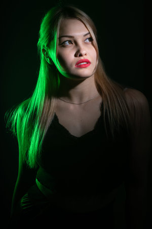 portrait of a blonde girl with bright makeup in green light.