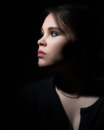 portrait of a girl sideways on a black background.copy space