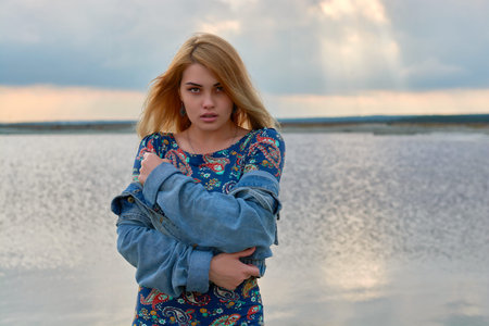 beautiful girl near the lake at sunset.