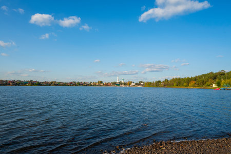 a lake on the background of a village on a sunny autumn dayの写真素材