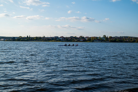 a boat in a lake with waves against a background of forest and sunset