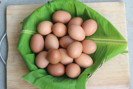 Eggs on banana leaf in a basket on wooden table.