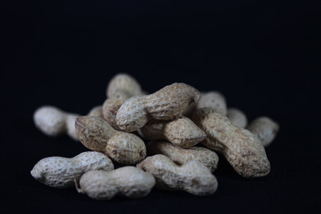 Peanuts on a black background. Selective focus with shallow depth of field.の写真素材
