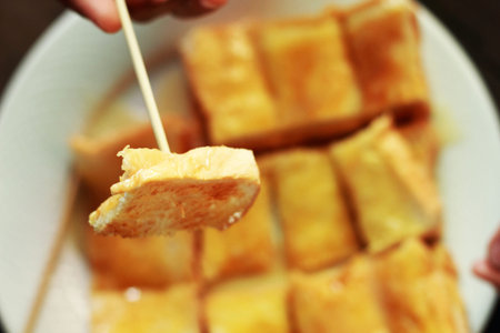 Children eat bread, butter, and milk in a dish.