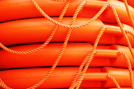 Stacked orange rescue round buoy, sea marine lifesaverの写真素材
