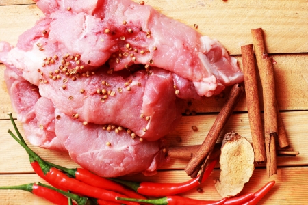 Raw pork on cutting board and vegetablesの写真素材
