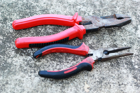 pliers red handle tool on the cement.