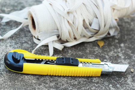 The yellow stationery knife on a white rope. 