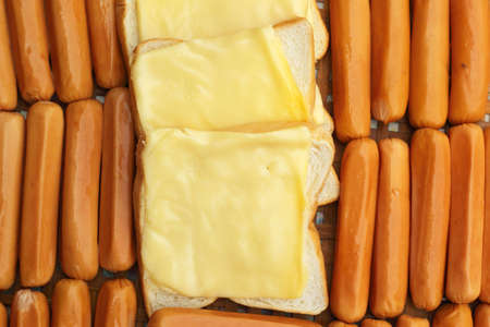 cheese the place on a slice of bread and sausage.の写真素材